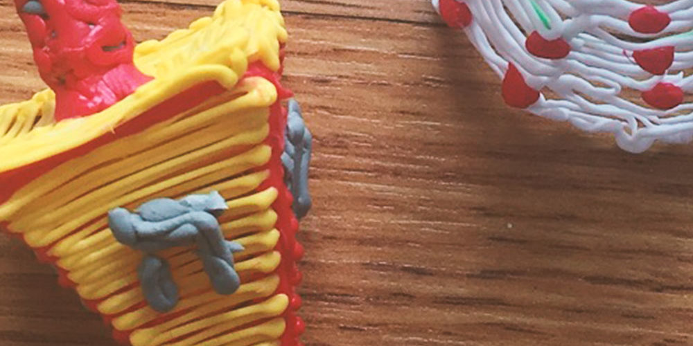 3D pen art: Dradel, cake, and cupcake on a table