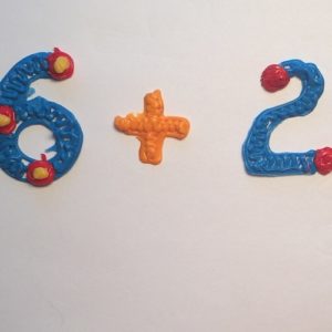 Close-up of number and toy airplane on table: 3D pen art.