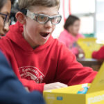 Surprised boy in red sweatshirt 3Doodler pens yellow box.