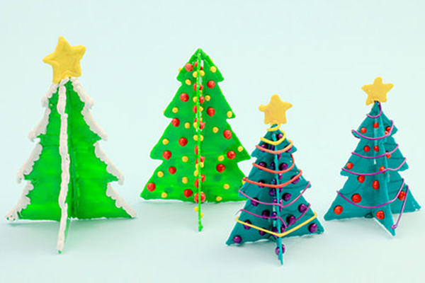 Brightly colored icing decorates 3D pen art: 3 Christmas trees with stars.