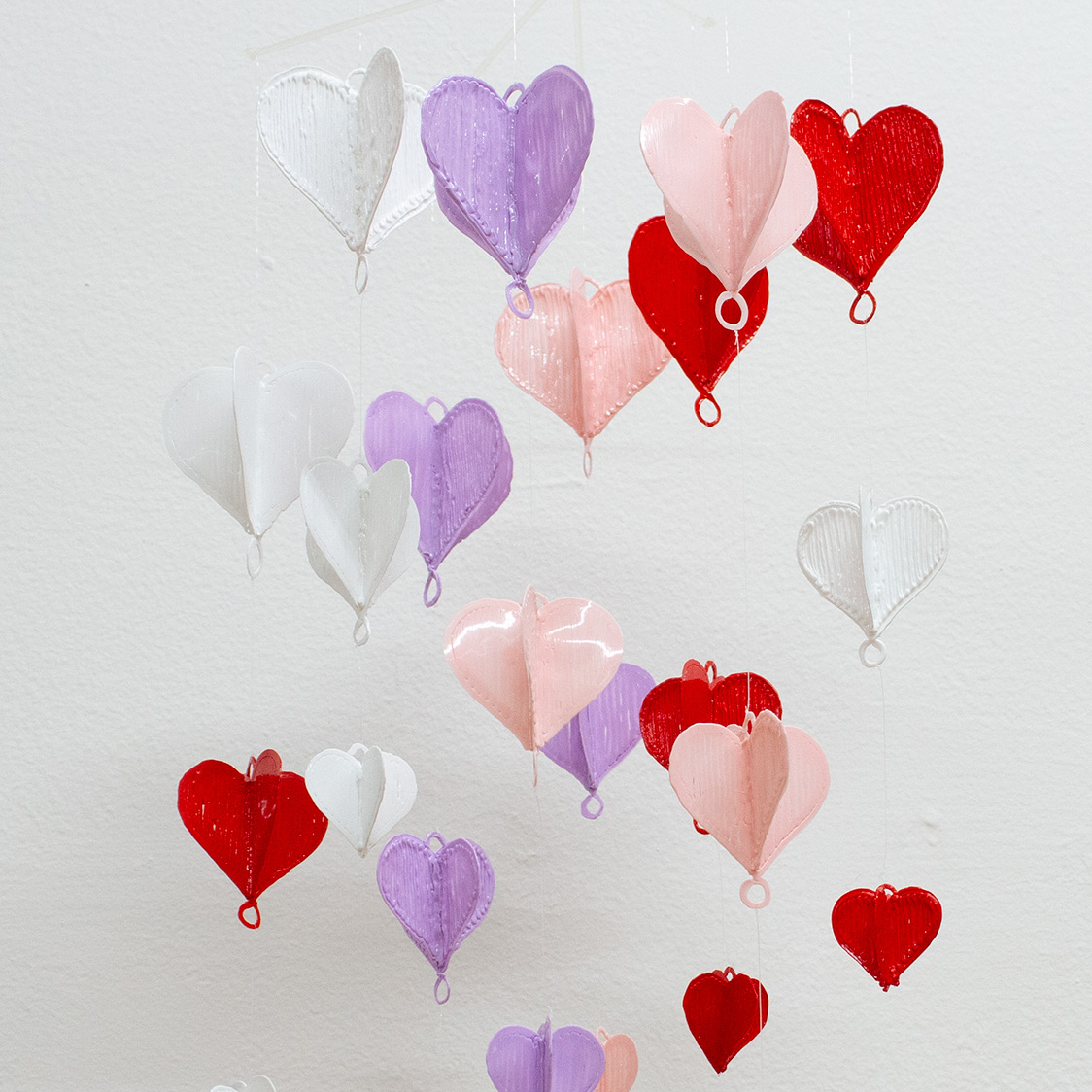 3D heart garland hanging from room ceiling.