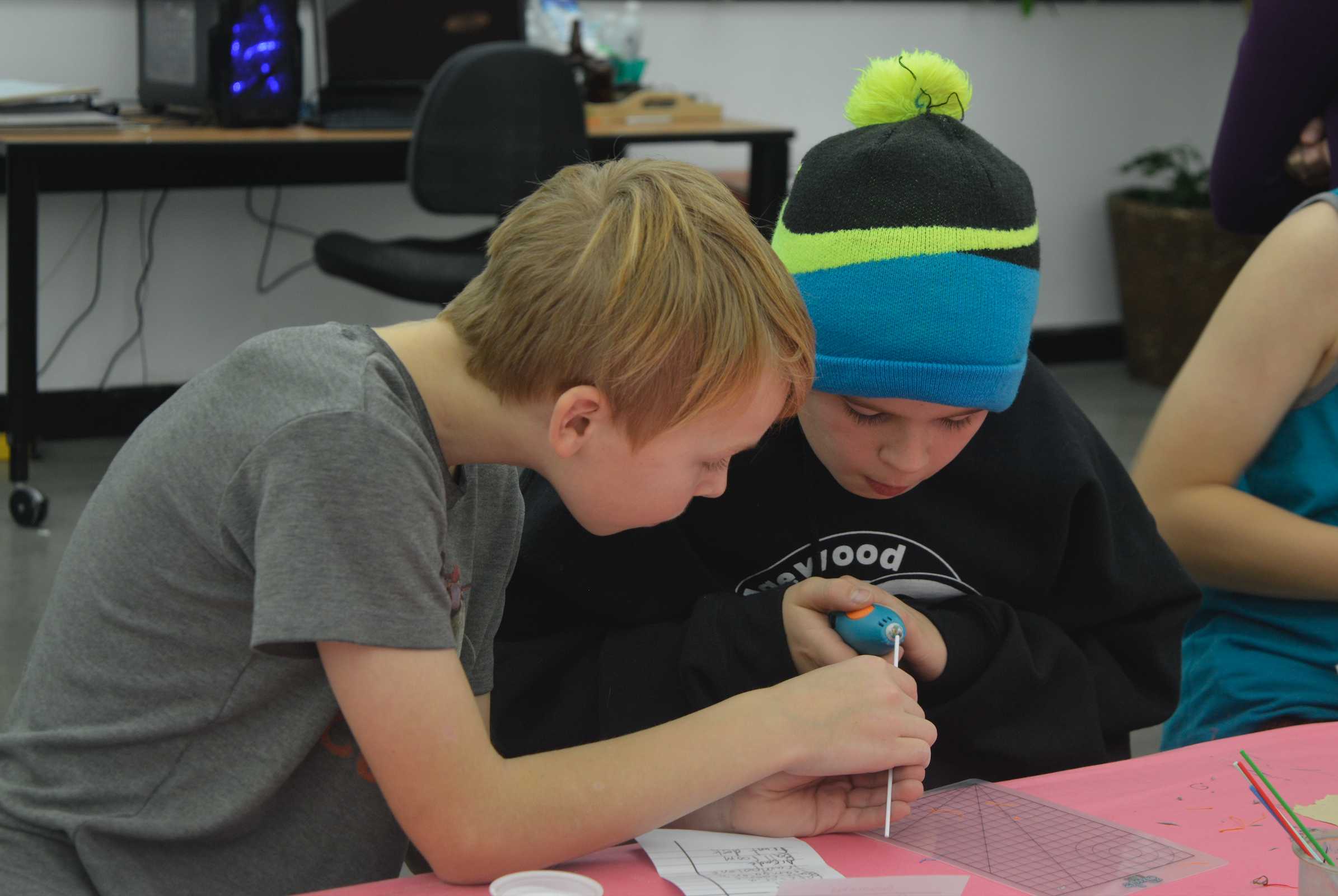 Boys creating cell phone 3D pen art at Bc Makerlab