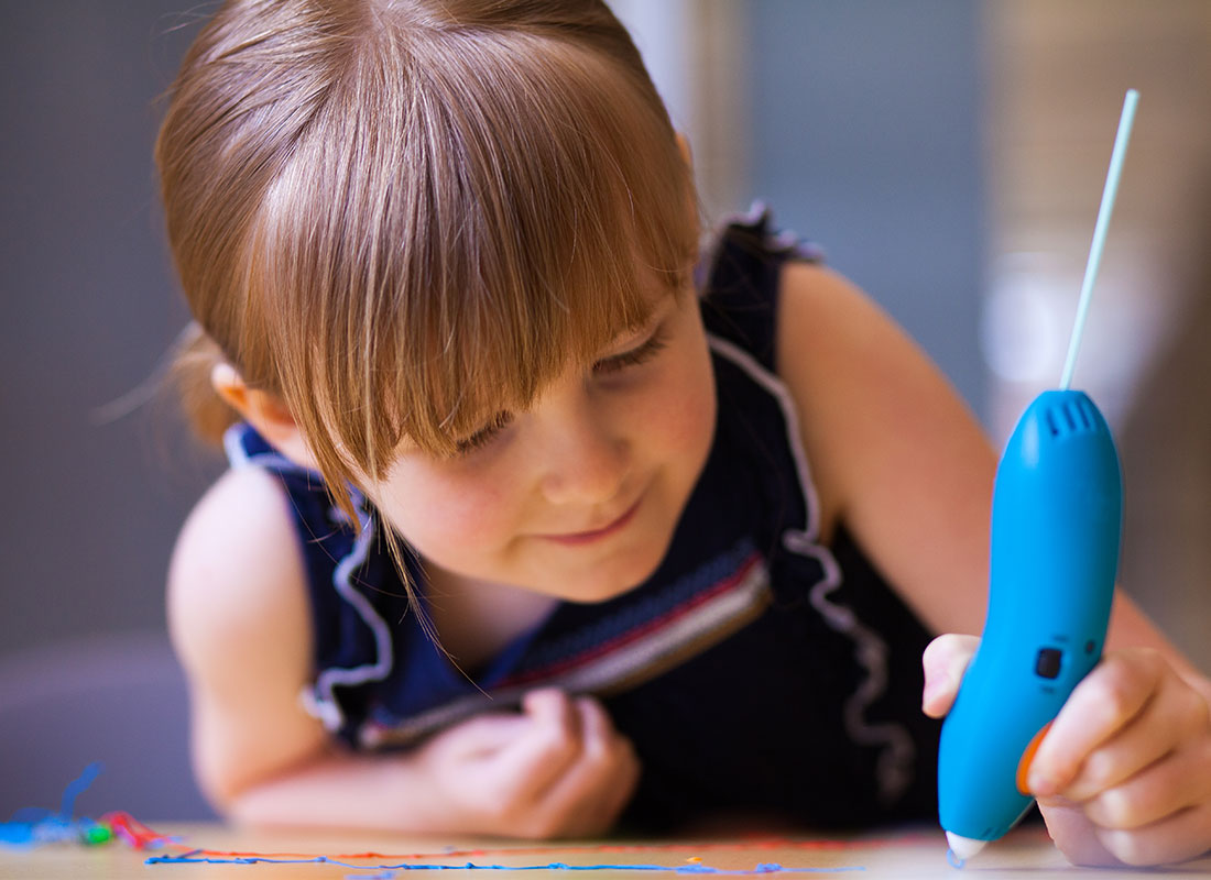 Little girl enjoying toy 3D pen art.
