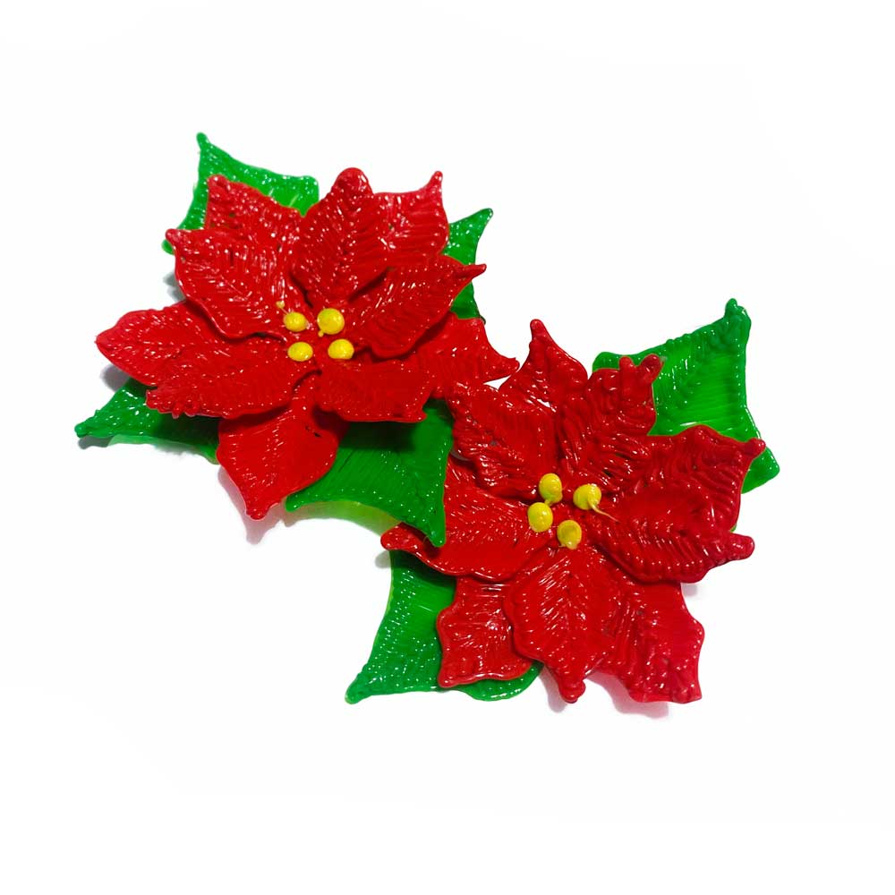 Red flowers with green leaves on white surface, created with a 3D pen.