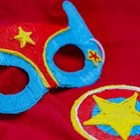 Close-up of intricate mask designs on vibrant red cloth, created with a 3D pen. | 3D Pen Template Stencil