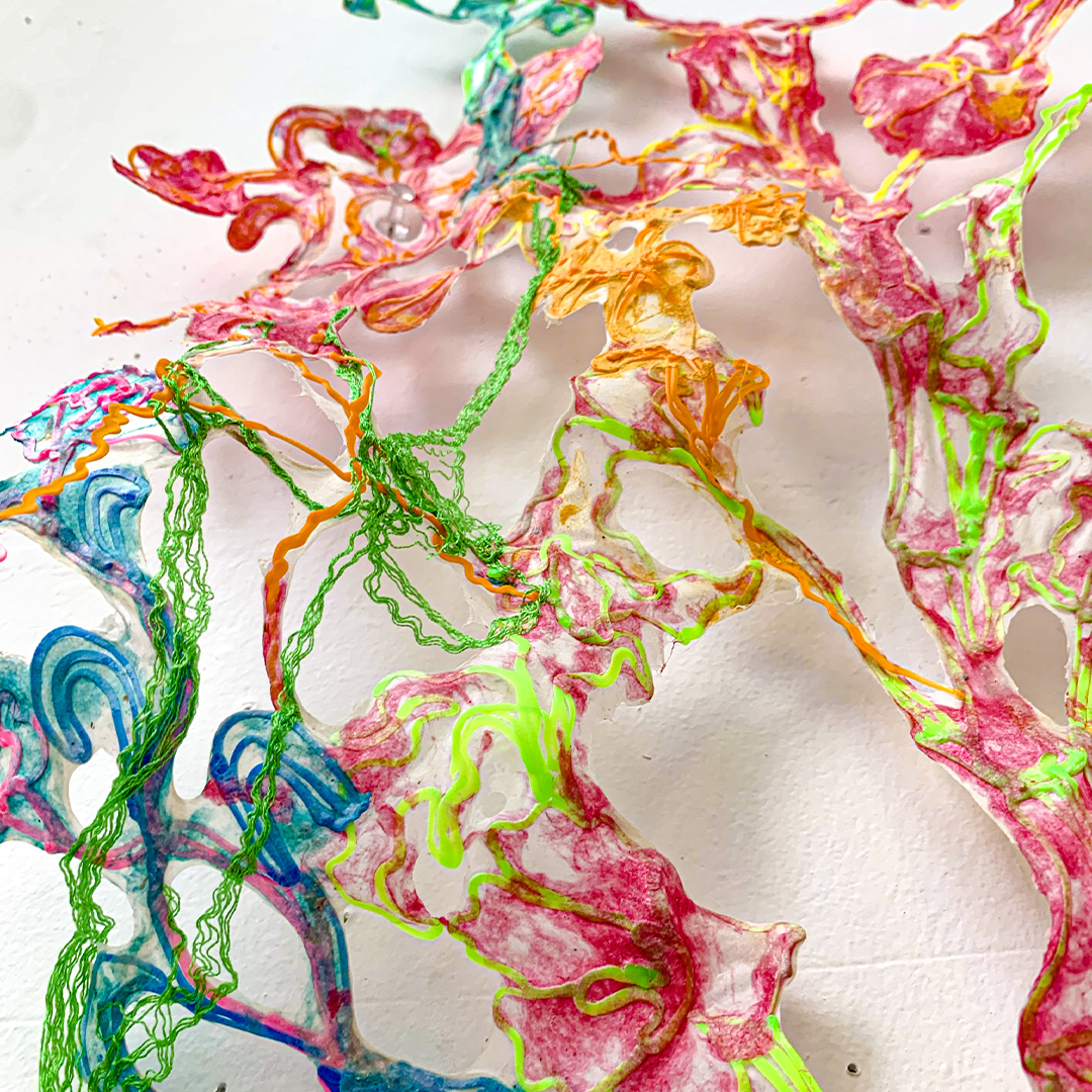 Vibrant yarn hanging on white wall in 3D pen art (53 characters)