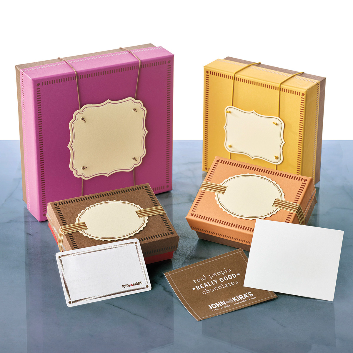 Three John & Kira's gift boxes with blank letterpress tags ready for a logo