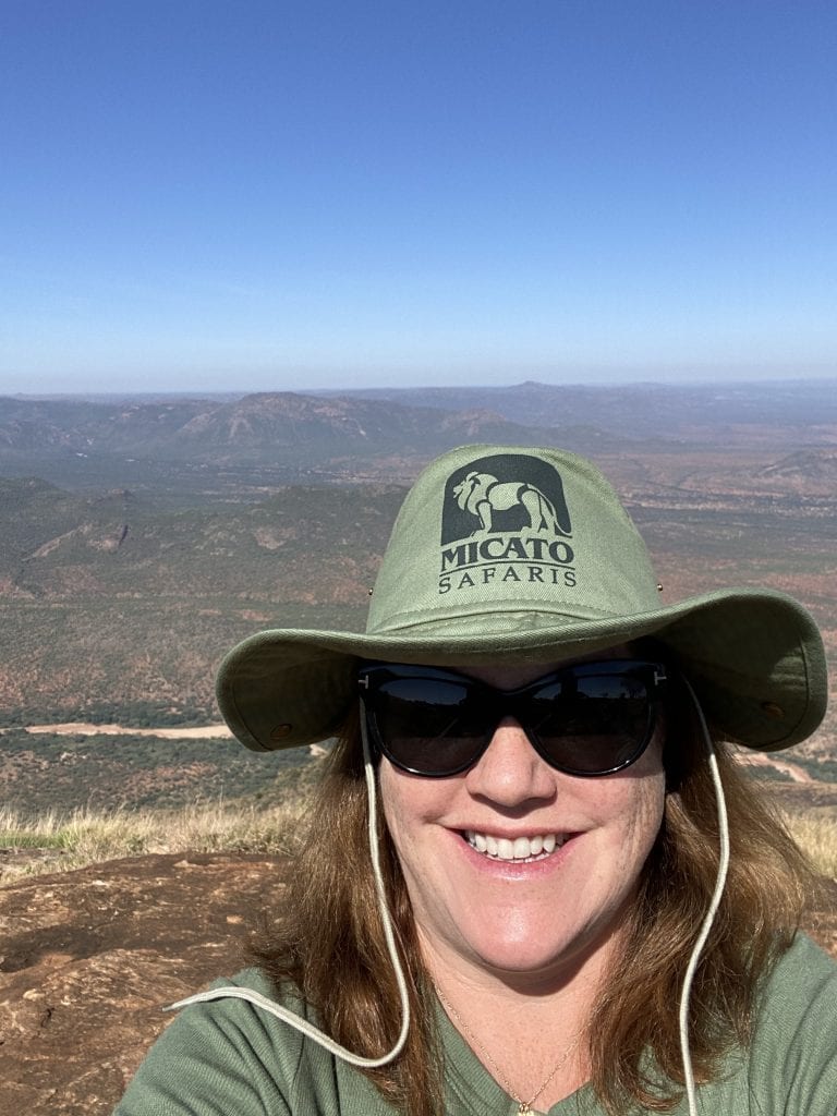smiling lady with kenya landscape