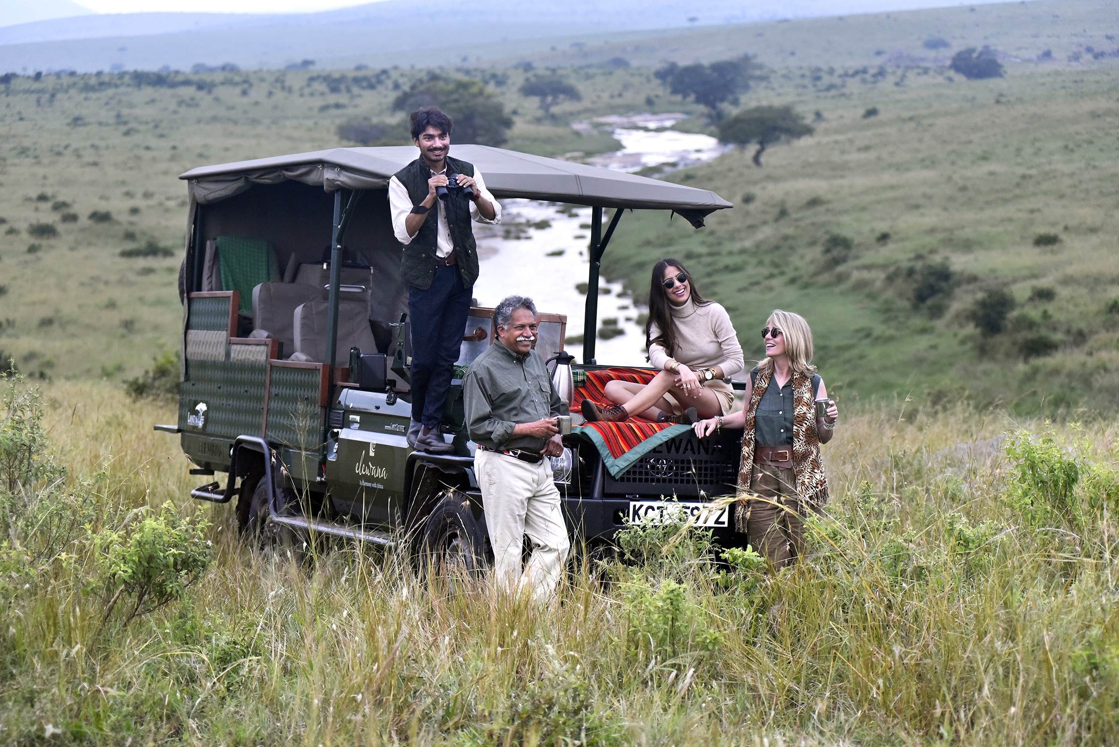 The Pintos standing next to a car