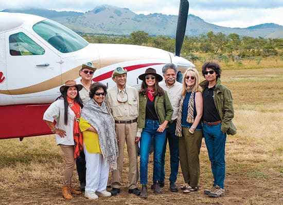 A group of tourists in front of a byplane