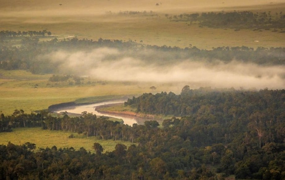 an aerial photo of land with fog over