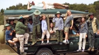 A family posing on a Micato Safaris truck.
