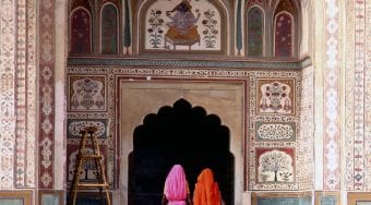 two ladies pass through doorway of Indian palace
