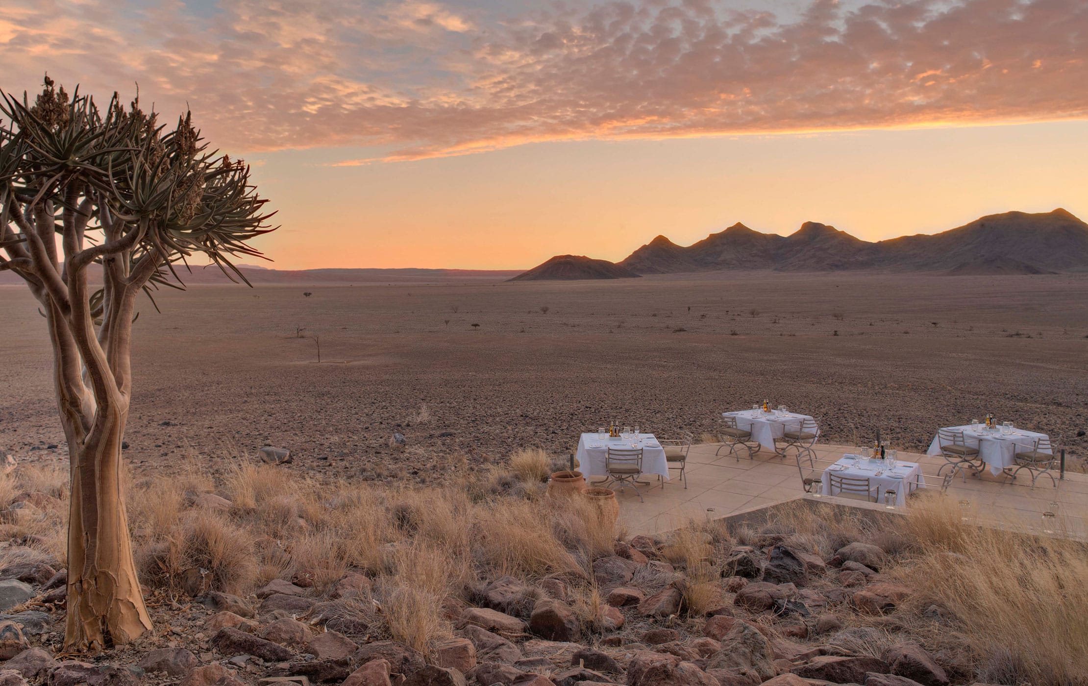 A group of tables set up for people to have a meal outside.