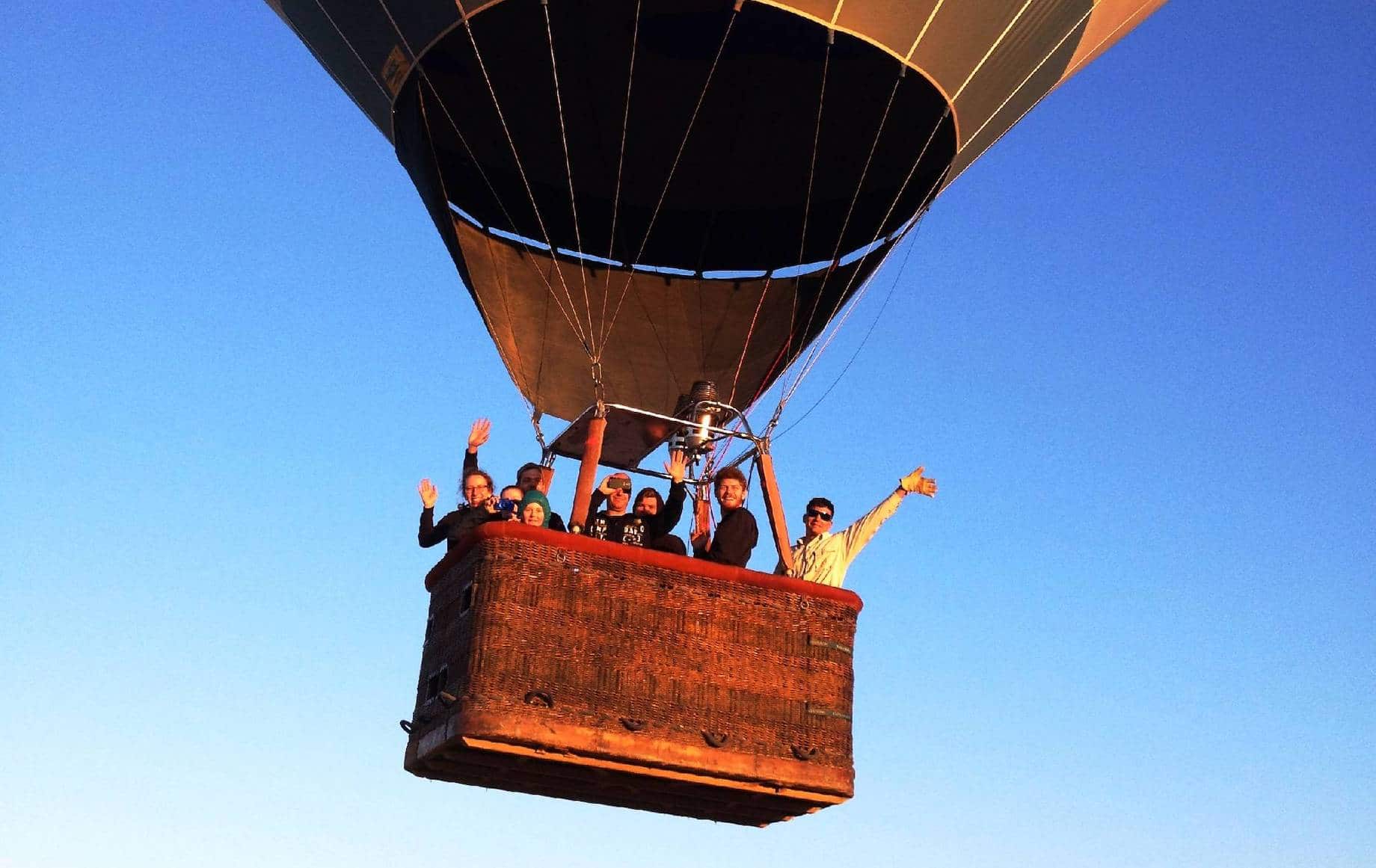 A group of travellers in the basket of a hot air balloon