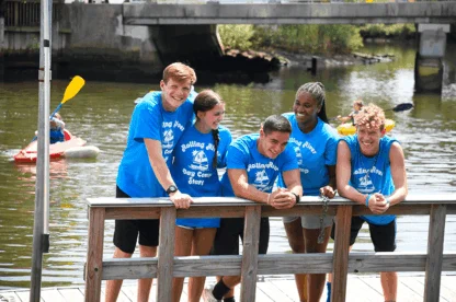 A group of Rolling River Day Camp crew members on a dock.