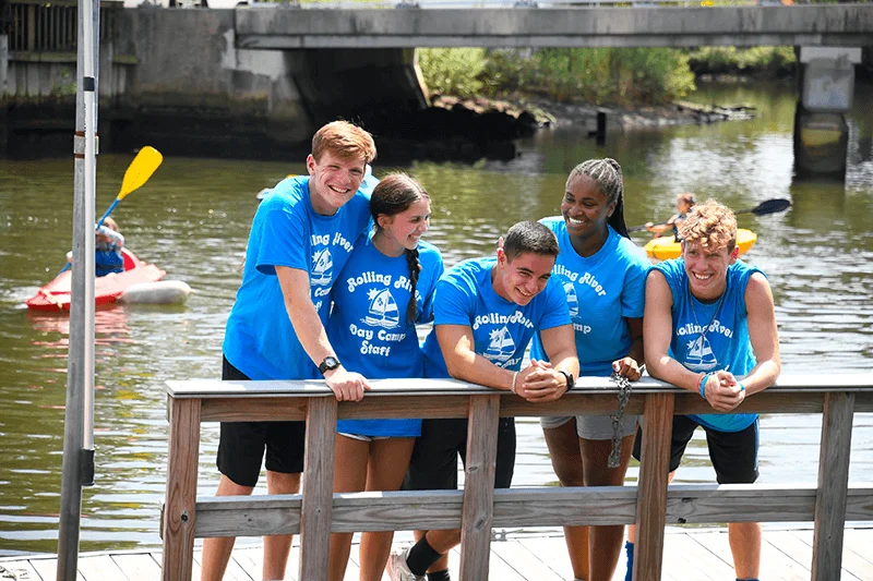 A group of Rolling River Day Camp crew members on a dock.