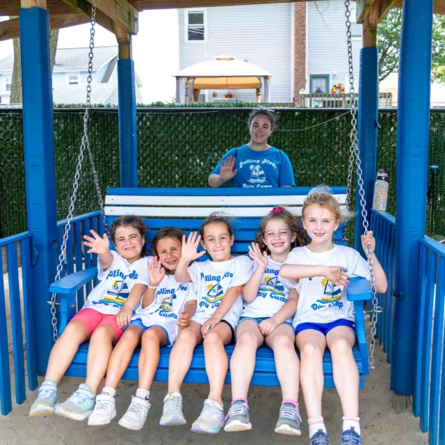 A group of mariner campers sitting on a swinging bench.