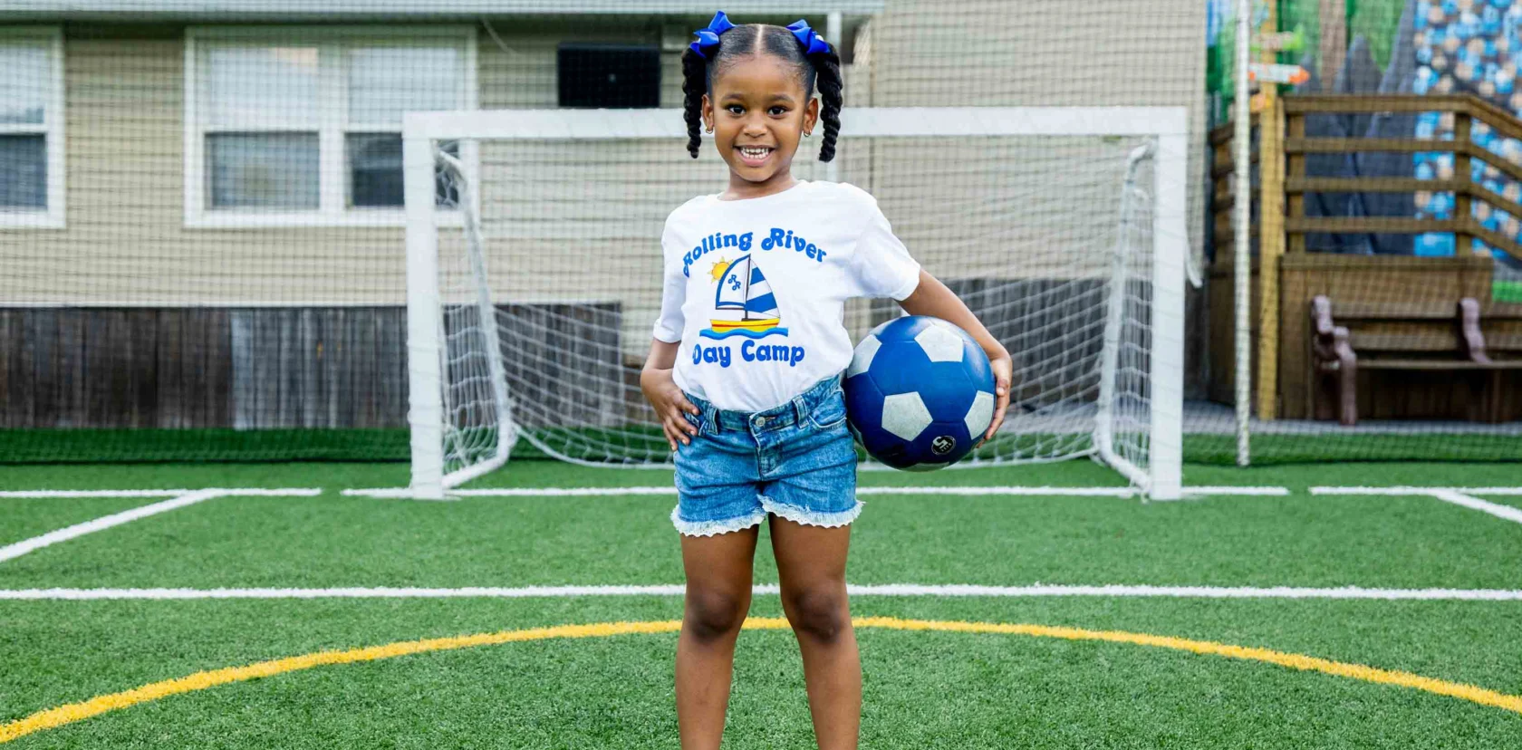 A camper holding a soccer ball.