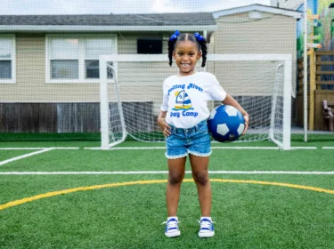 A camper holding a soccer ball.