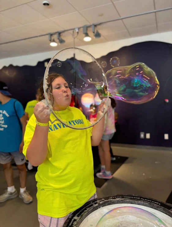 A camper blowing a bubble.