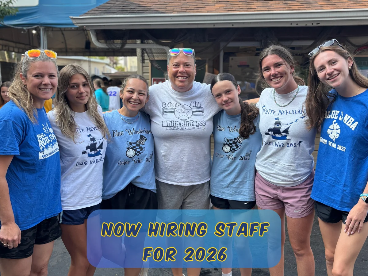 Two camp staff members smiling together on a play structure at Rolling River Day Camp||