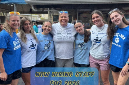 Two camp staff members smiling together on a play structure at Rolling River Day Camp||