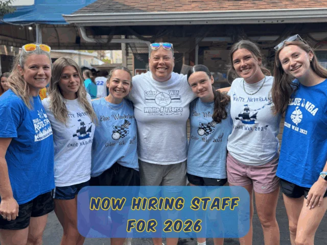 Two camp staff members smiling together on a play structure at Rolling River Day Camp||