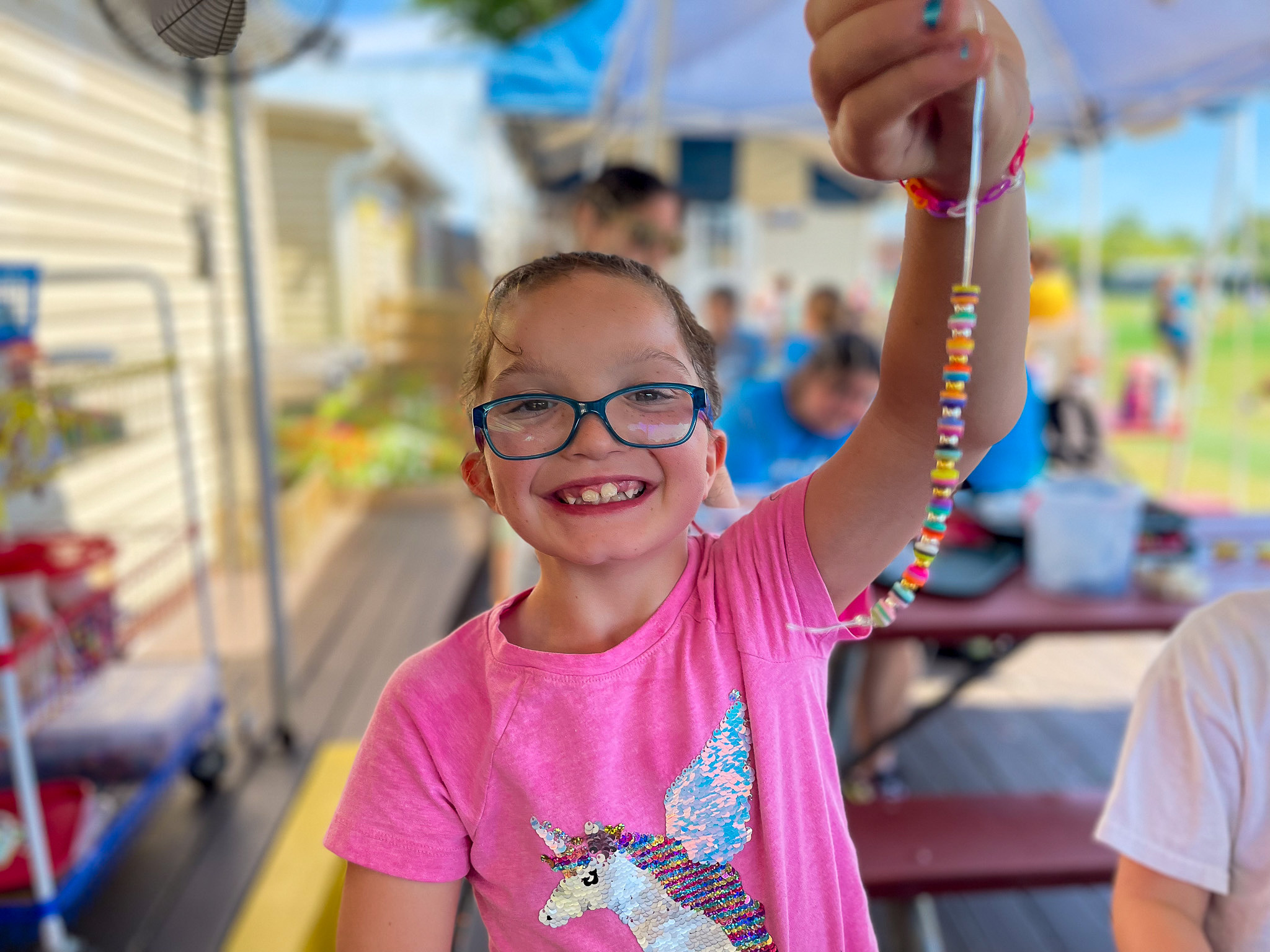 A camper holding a beaded bracelet.