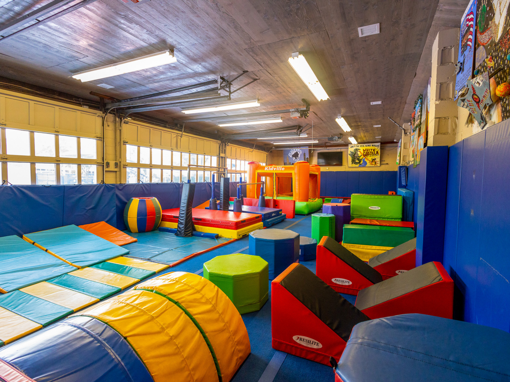 indoor tumbling center featuring trampolines, bounce house, gymnastics bars, balance beam and ninja course.
