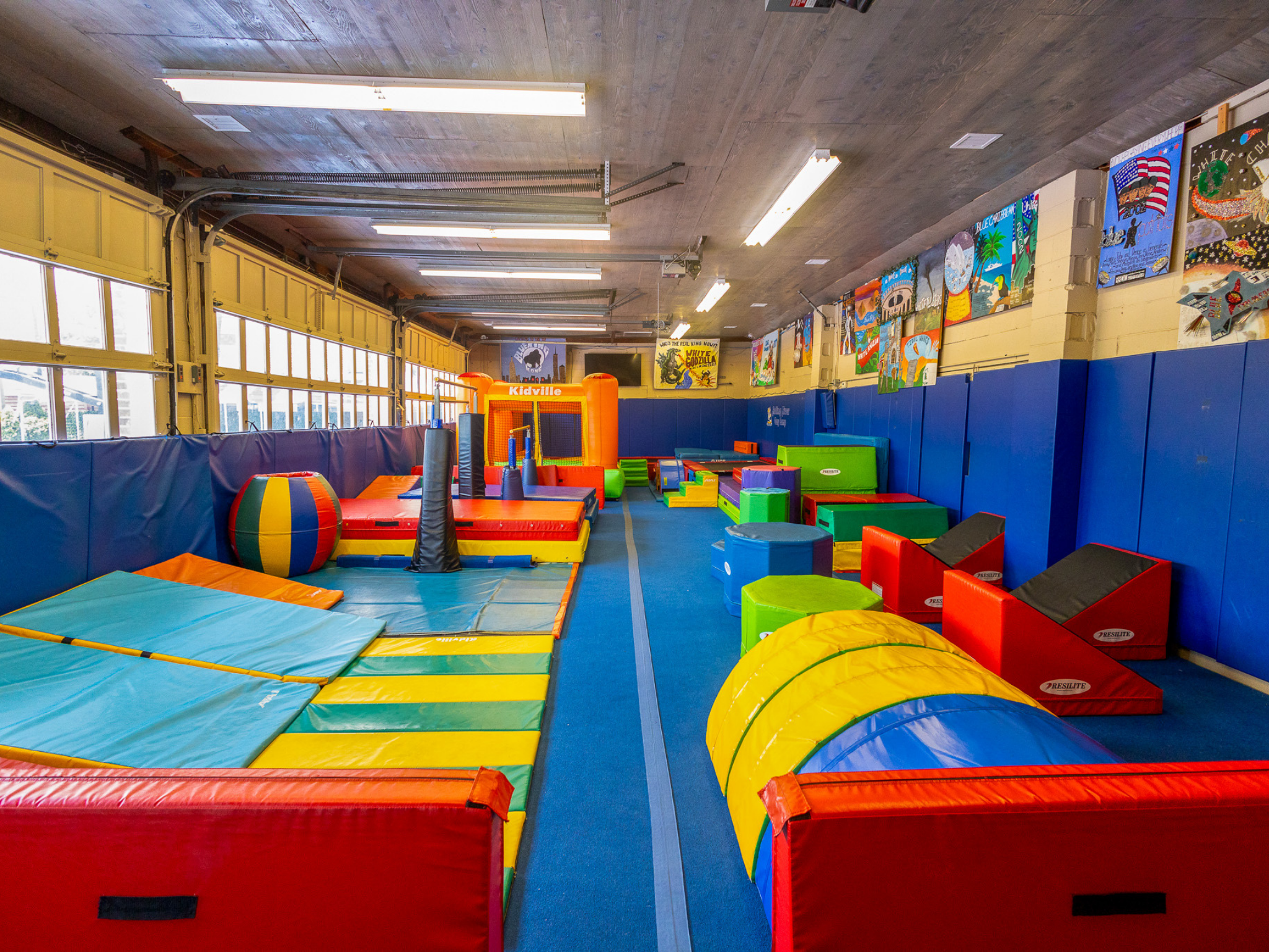 indoor tumbling center featuring trampolines, bounce house, gymnastics bars, balance beam and ninja course.