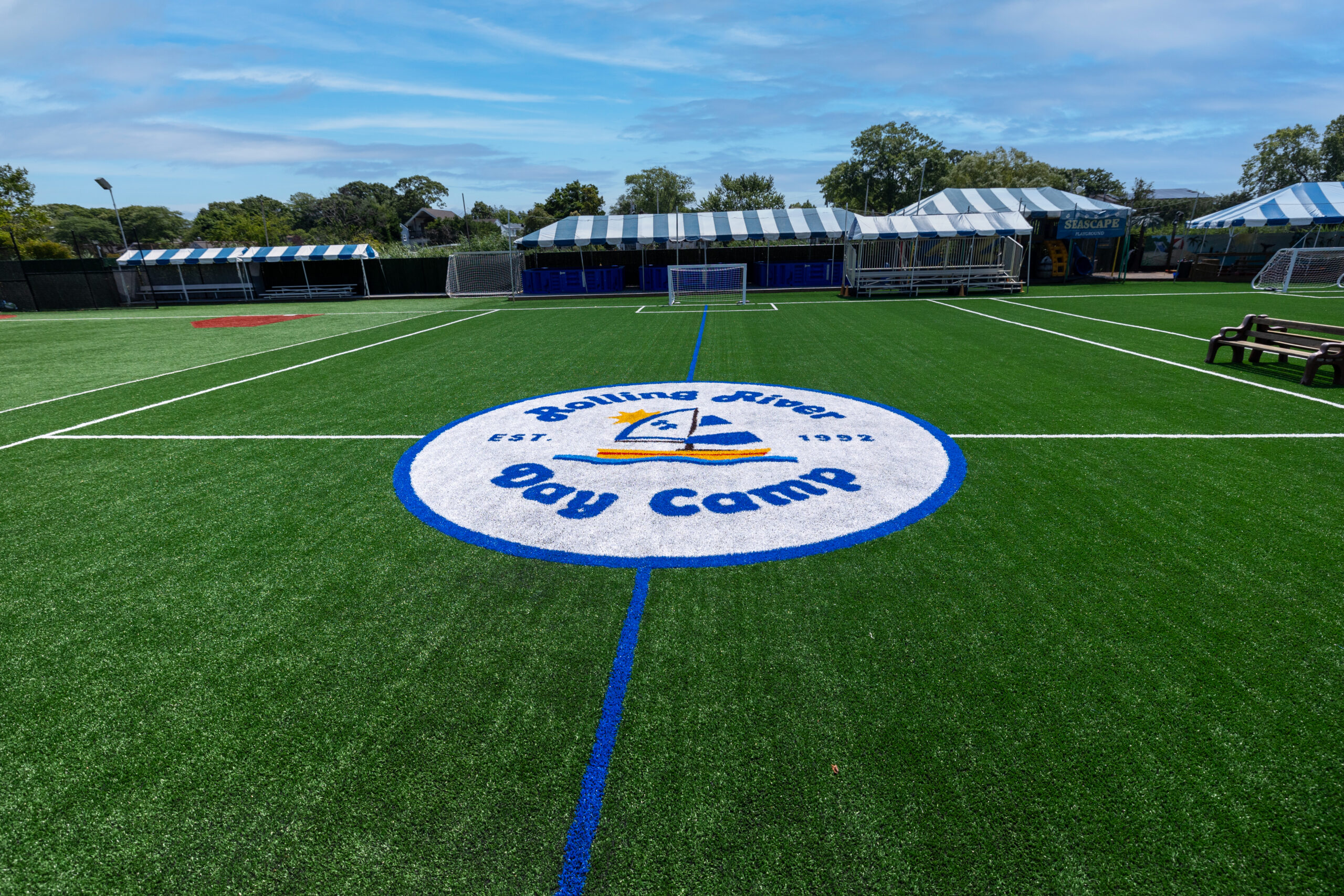 Turf field with Rolling River Day Camp logo.