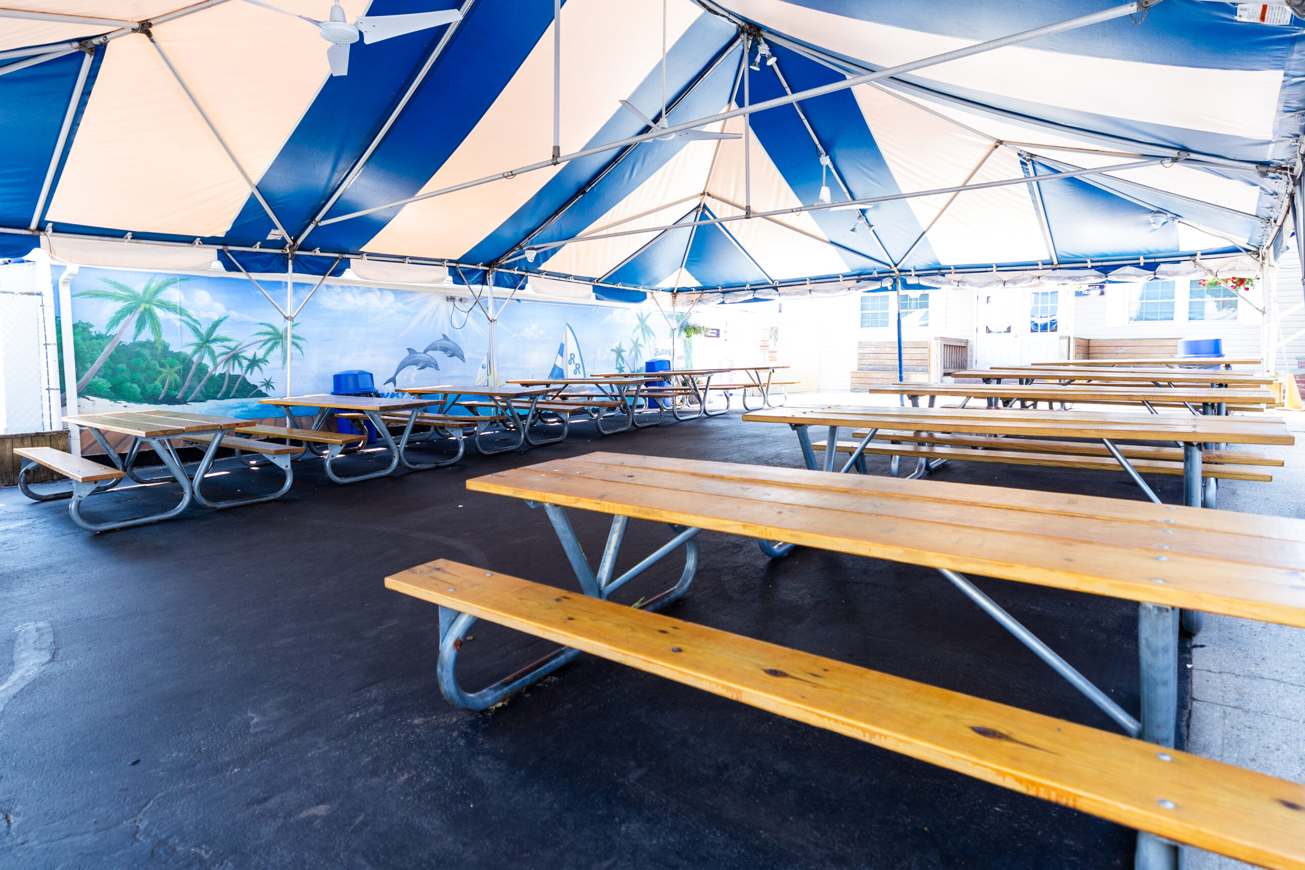 Tented courtyard with two dozen picnic tables used for snack and lunch.