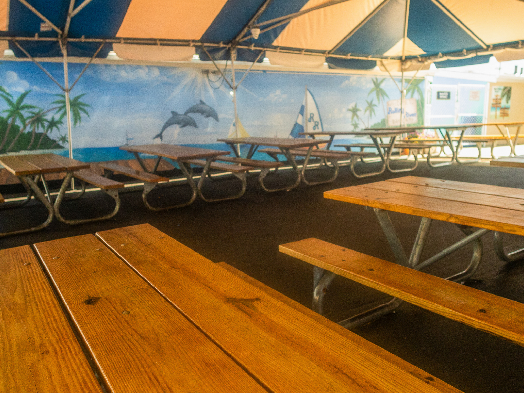Tented courtyard with two dozen picnic tables used for snack and lunch.
