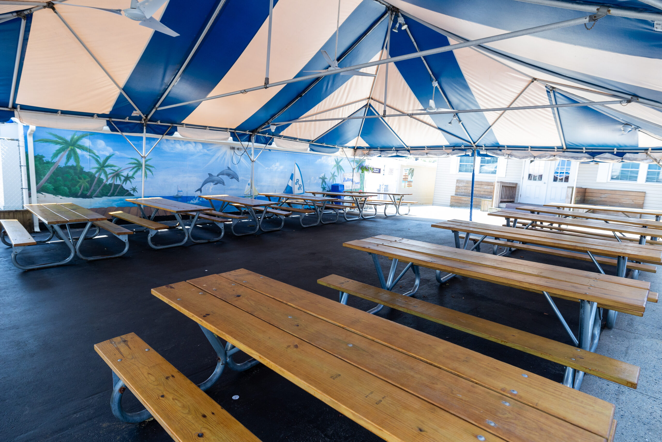 Tented courtyard with two dozen picnic tables used for snack and lunch.