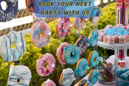 Colorful birthday donuts decorated with icing and sprinkles displayed at a Rolling River Day Camp party setup