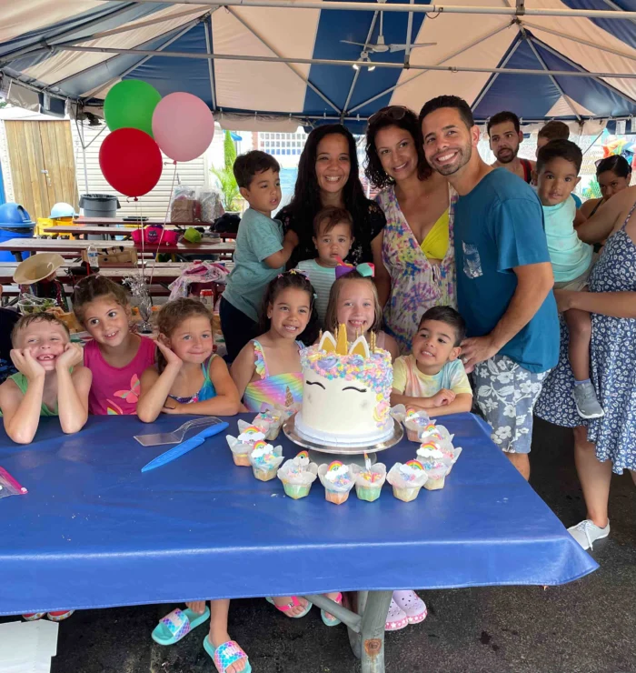 A child having a birthday party surrounded by friends.