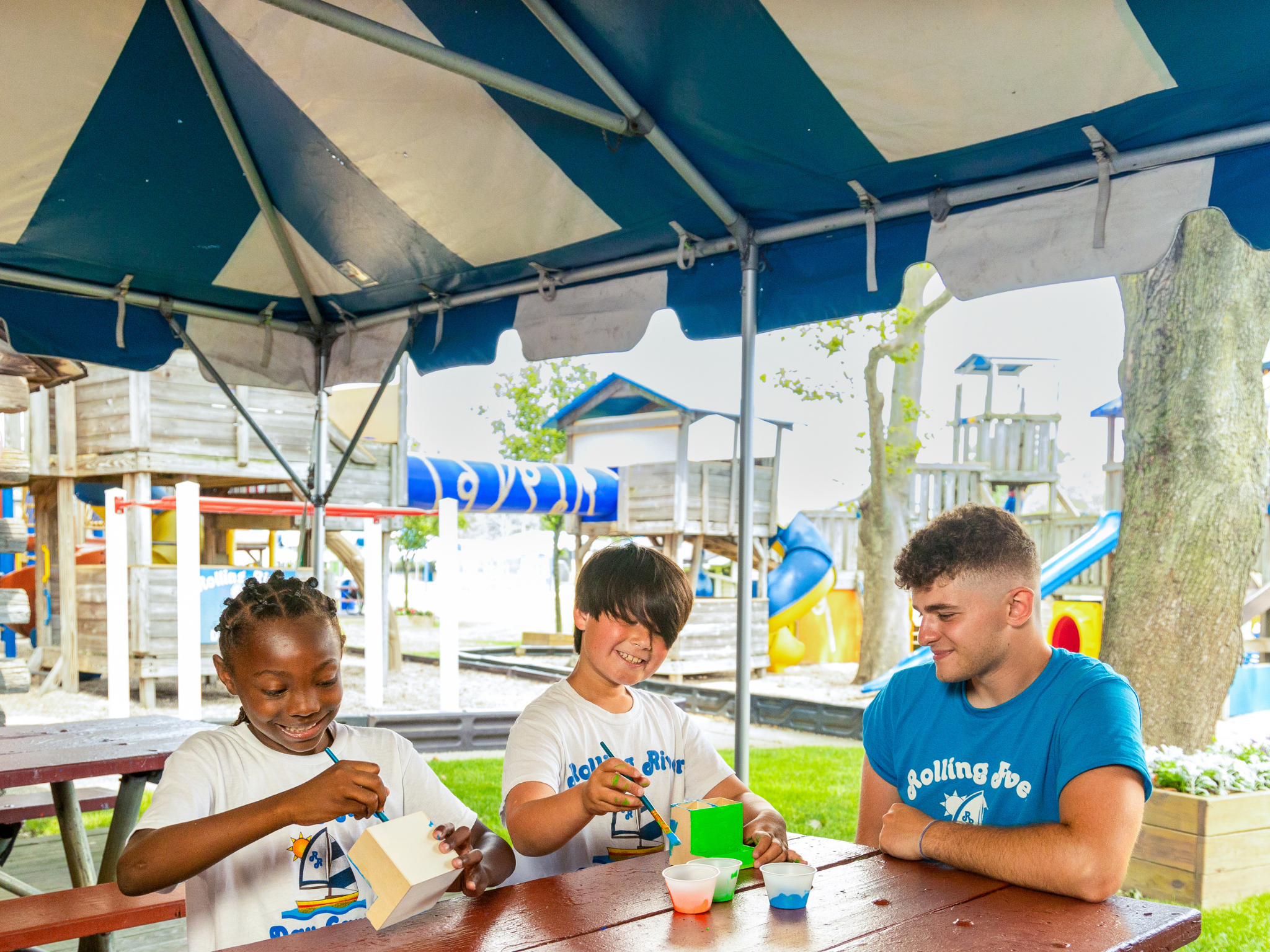 Two campers woodworking alongside an instructor.