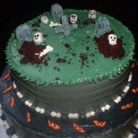 Halloween Cake 2 Tier Chocolate Cake with Chocolate filling. Iced in Dark Grey Butter Cream with Gum Paste Graveyard and Green grass. "Dirt" is...