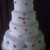 Beth Wedding Cake White cake with buttercream, fondant covered and flowers.