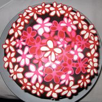 Flower Cake Top View chocolate cake with oreo filling, frosted with raspberry imbc, covered with chocolate mmf, and decorated with pink, red, and white...