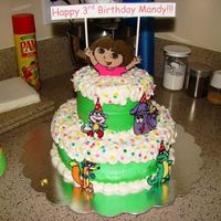 Dora Birthday Cake Yellow cake, frosted with bc. 10" bottom tier, 6" top tier. Characters are chocolate transfers.
