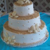 At The Beach 6in, 10in, 14in round tiers with buttercream icing. The sand is made from brown sugar and the shell were made in a shell mold and candy...