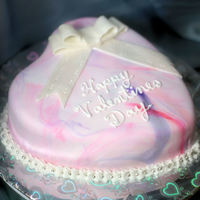 Hearts White cake with marbled pink and purple fondantLeaf tip buttercream trim with silver candy ballsFondant ribbon with pearl dust