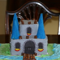 Castle Cake Castle Cake for my 6 year old son's bday. 3 8x8 layers stacked for bottom portion, then 2 2x2 pieces stacked for top. Ice cream cones...