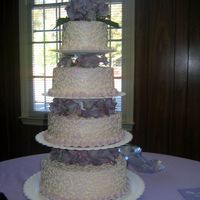 Img_2950_Edited.jpg My 2nd wedding cake for my cousins wedding. I had about 2 weeks notice and she never told me anything except purple. I chose to frost the...