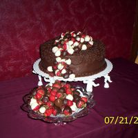 Tumbling Strawberries Two layer chocolate cake (12") with choclate covered strawberries tumbling over the top and side. This cake was made for a rehearsal...