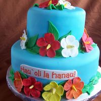 Hawaiian Bday Cake My first real cake covered in fondant. I don't know if I will do another one, but who knows. MMF with gumpaste flowers and EI words on...