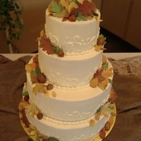 Fall Wedding Cake 4 tier wedding cake with buttercream icing and gumpaste leaves in multiple colors.