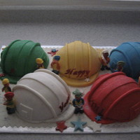 Construction Guys Bunch of hard hats in the appropriate colors this company usesin the team. Variety of cakes and covered in MMF.